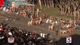 a crowd of people are watching a parade with the number 5 on the bottom right
