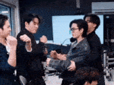 a group of men are standing in a room holding hands .
