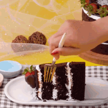 a person is cutting a slice of cake with strawberries on it