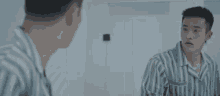 a man is looking at himself in a mirror and touching his face .