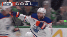 a hockey player celebrates a goal in front of a crowd