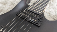 a close up of a black jackson guitar
