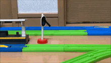 a toy train track with green and blue tracks and a sign that says ' a ' on it