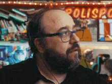 a man wearing glasses stands in front of a sign that says polispark