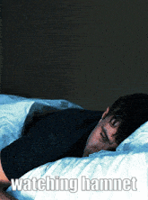 a man is sleeping in a bed with the words watching hamnet written below him