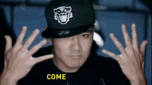a man wearing a hat with a tiger on it and the word come on the bottom