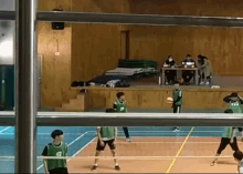 a group of people are playing volleyball in a gym and one of the players has the number 42 on their jersey