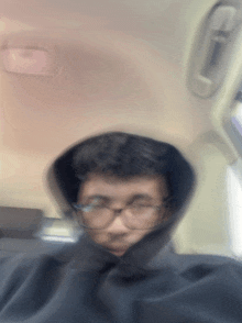 a blurry picture of a person wearing glasses and a hood