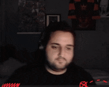 a man is making a funny face while sitting in front of a screen .