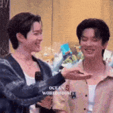 a couple of young men are standing next to each other and laughing .