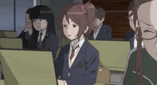 a girl in a school uniform is sitting in front of a computer