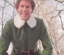 a man in a green elf costume is smiling