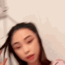 a blurry picture of a woman 's face with her hair in a ponytail .