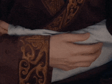 a close up of a person 's hands with a brown cuff