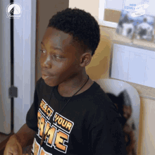 a boy wearing a black shirt that says " select your game "