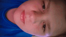 a close up of a person 's face with their mouth open and a blue shirt on .