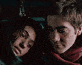 a man and a woman are laying next to each other in a car .