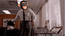 a man wearing a virtual reality headset is dancing in an office with the words solana apes trading club above him
