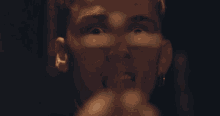 a man is holding a syringe in his hand in front of his face .