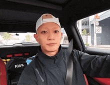 a man is sitting in a car with a bag that says как on it