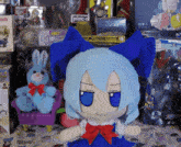 a stuffed doll with blue hair and a red bow sits in front of a bunch of toys including a conan comic book