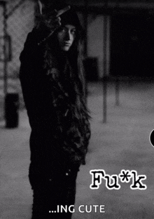 a black and white photo of a girl giving the middle finger with the words " fu*k ... ing cute " below her