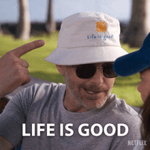 a man wearing a white hat with the words life is good on it