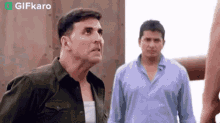 two men are standing next to each other and one of them is looking up at the sky .