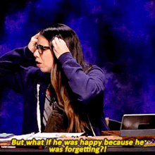 a woman is sitting at a desk with her hands on her head and says but what if he was happy because he was forgetting ?