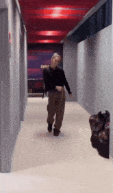 a man is walking down a hallway with a sign that says army