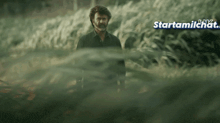 a man is standing in a field with the words starttamilchat.com in the upper right corner