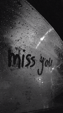 a black and white photo of a car window that says miss you