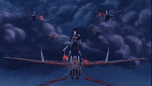 a group of helicopters are flying in the sky and a person is standing on top of one of them .