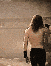 a man without a shirt is standing in front of a wall with the word orderr written on it