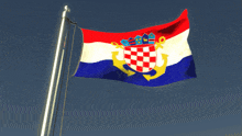 a red white and blue flag with a coat of arms