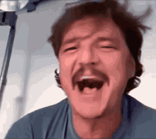 a man with a mustache is laughing with his mouth wide open