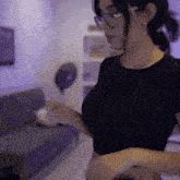 a woman wearing glasses and a black shirt with xg written on the bottom