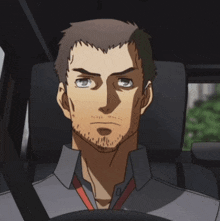 a man with a beard sits in a car with his eyes closed