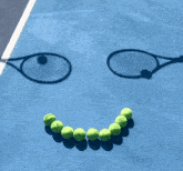 a bunch of tennis balls are arranged in the shape of a smile on a tennis court