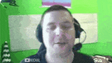 a man wearing headphones and a headset is looking at the camera .