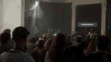 a group of people are sitting in front of a screen that says blind creation company of us