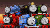 a bunch of thomas the tank engines are sitting next to each other on a train track .