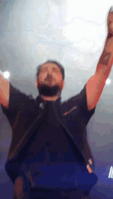 a man with his arms in the air has a tattoo on his arm that says ' i love you '