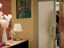 a table with a lamp and a painting on the wall