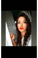 a woman with red lipstick on her lips is standing in front of a window