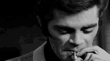 a man in a suit is smoking a cigarette