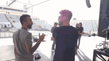 a group of people are standing in a stadium and talking to each other