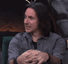a man in a gray shirt is making a face