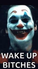 a close up of a clown 's face with the words `` wake up bitches '' written above it .