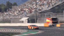 a race car is driving on a track with a crowd in the background